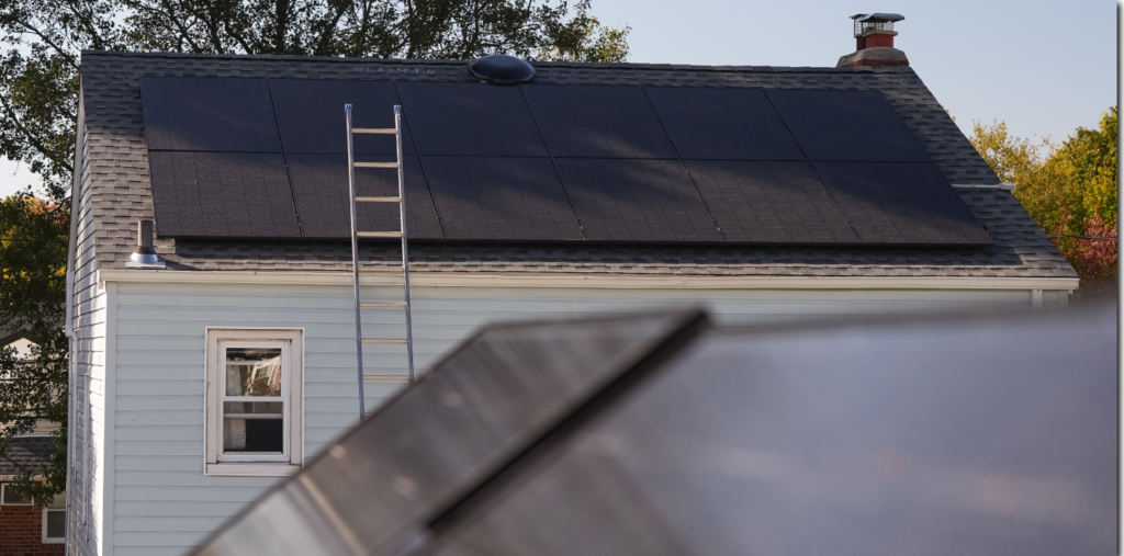 Home with rooftop solar panels and a ladder set up for service
