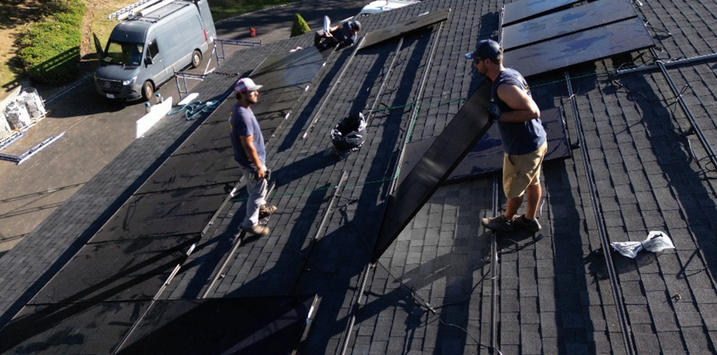 Crew working on a residential roof with solar panels removed for roof work